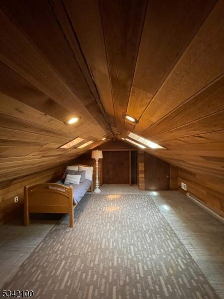 bonus room featuring lofted ceiling, wood walls, and wood ceiling