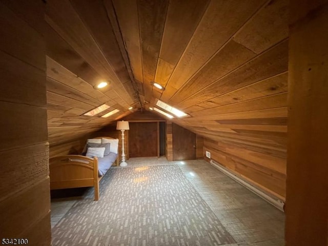 additional living space featuring vaulted ceiling with skylight, wood walls, and wood ceiling