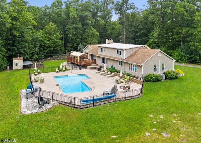 view of pool with a patio area, fence, a lawn, and a wooden deck