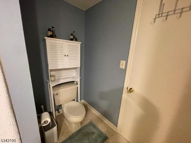 bathroom with toilet and baseboards