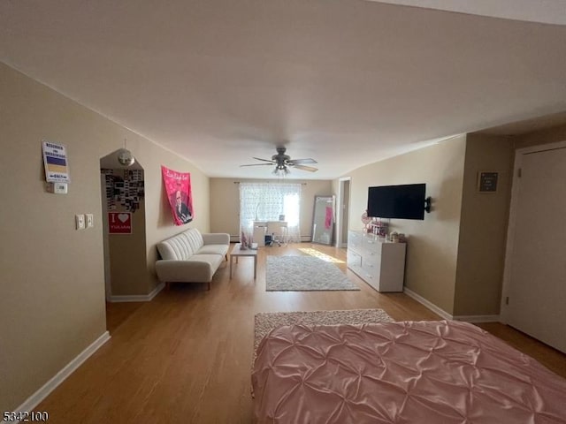 unfurnished living room featuring ceiling fan, light wood-type flooring, and baseboards