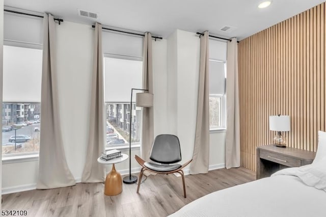 bedroom featuring multiple windows, visible vents, and wood finished floors