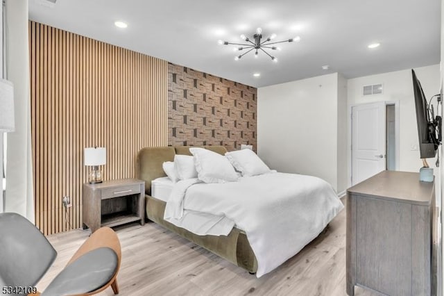 bedroom featuring recessed lighting, visible vents, an accent wall, a chandelier, and light wood-type flooring