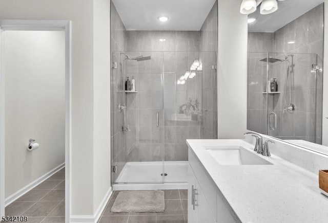 bathroom featuring baseboards, a shower stall, vanity, and tile patterned floors