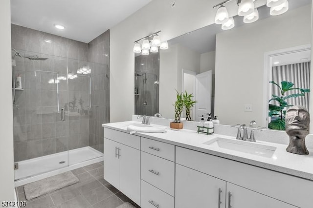 bathroom featuring double vanity, tile patterned floors, a sink, and a shower stall