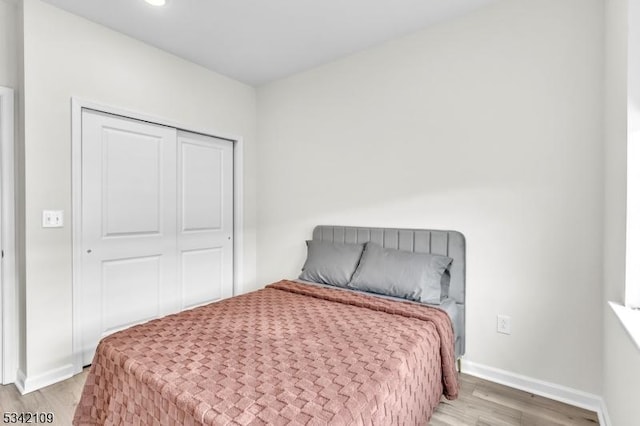 bedroom with light wood finished floors and baseboards