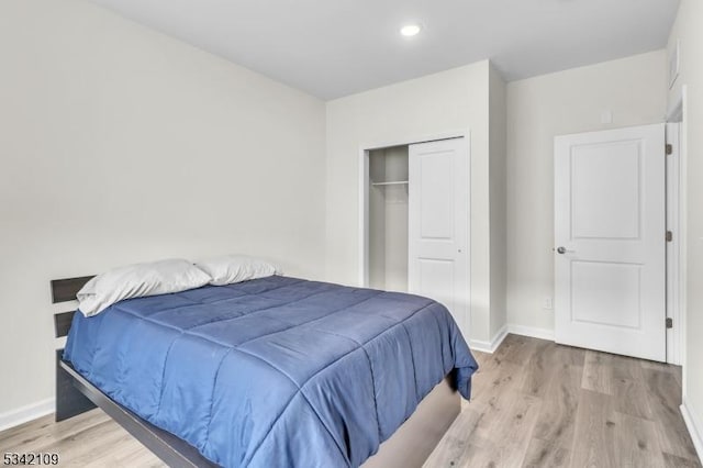 bedroom featuring a closet, recessed lighting, light wood-style flooring, and baseboards