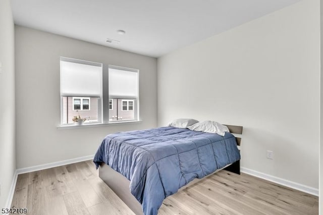 bedroom featuring baseboards and wood finished floors