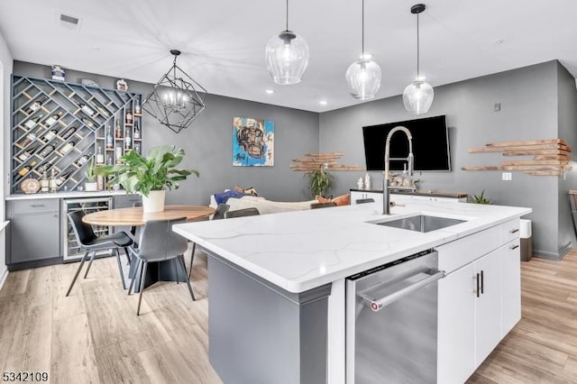 kitchen with wine cooler, a sink, white cabinets, light wood-style floors, and dishwasher