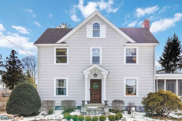 view of front of house featuring a shingled roof and a chimney