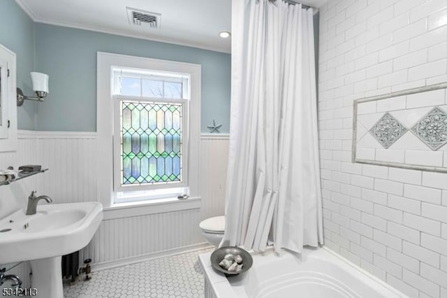 full bath with a wainscoted wall, a wealth of natural light, toilet, and visible vents