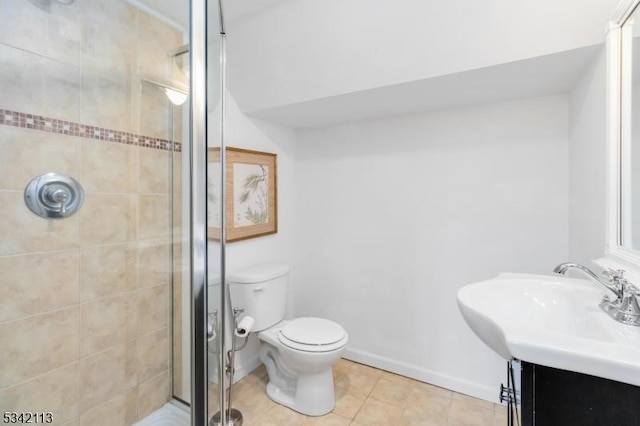 bathroom featuring toilet, vanity, baseboards, a shower stall, and tile patterned floors