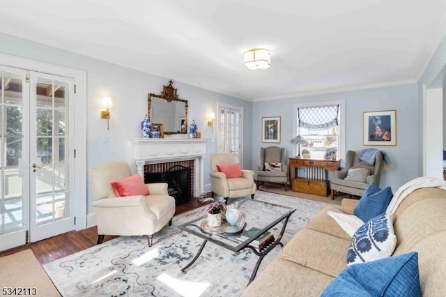 living area with crown molding, a fireplace, wood finished floors, and french doors