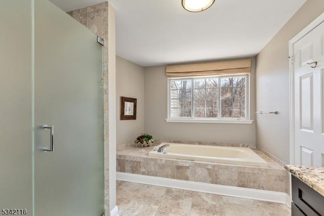 bathroom with a stall shower, vanity, and a bath