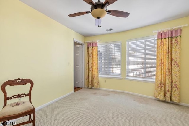 sitting room with baseboards, carpet floors, and ceiling fan