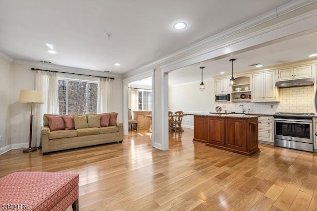 living room with crown molding, baseboards, and light wood finished floors