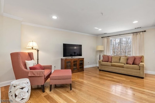 living room featuring visible vents, crown molding, light wood-type flooring, and baseboards