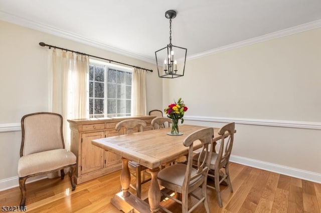 dining space with light wood-style flooring, baseboards, and ornamental molding