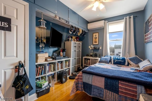 bedroom featuring a wall unit AC, ceiling fan, and wood finished floors