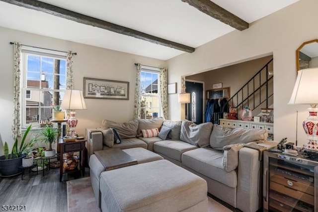 living area featuring stairs, beamed ceiling, and wood finished floors