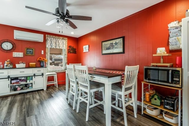 dining space with dark wood-style floors, a ceiling fan, and a wall mounted AC