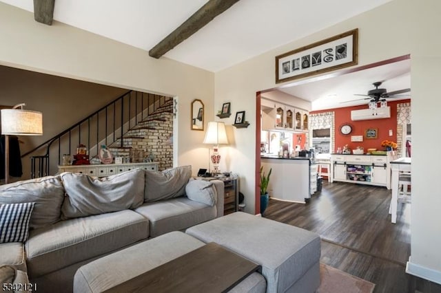 living room featuring ceiling fan, dark wood-style flooring, stairway, a wall mounted AC, and beamed ceiling