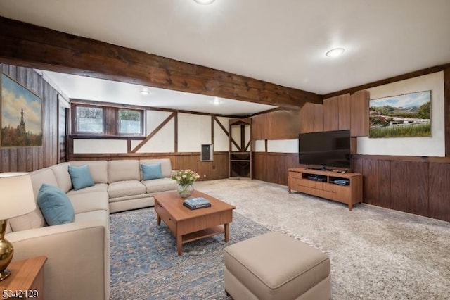 carpeted living room featuring wood walls, beamed ceiling, and wainscoting