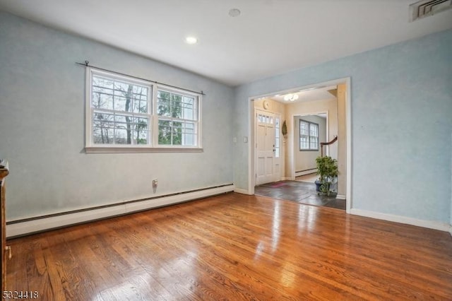 spare room with a healthy amount of sunlight, a baseboard radiator, visible vents, and a baseboard heating unit
