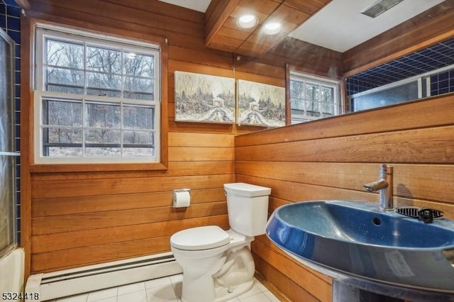 bathroom featuring a baseboard heating unit, a sink, and wooden walls