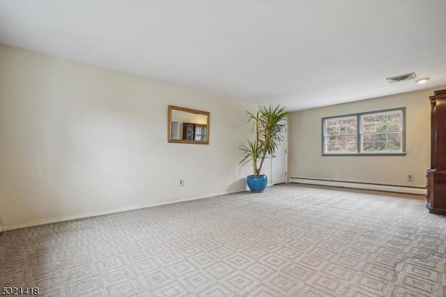 empty room with a baseboard radiator, visible vents, and baseboards