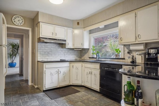 kitchen featuring stone tile floors, dark countertops, a sink, under cabinet range hood, and black appliances