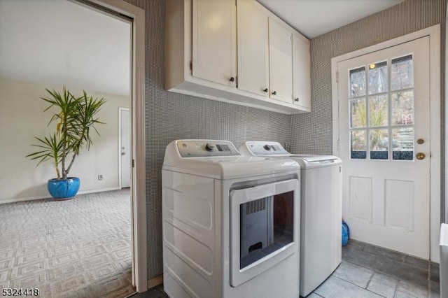 clothes washing area featuring washing machine and clothes dryer and cabinet space