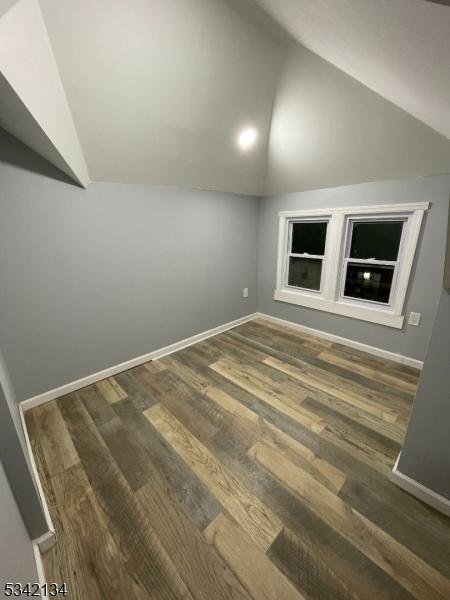 additional living space featuring vaulted ceiling, wood finished floors, and baseboards