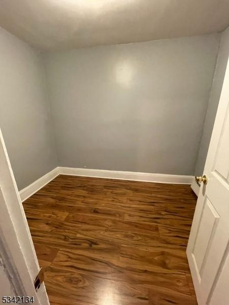 unfurnished room featuring baseboards and wood finished floors