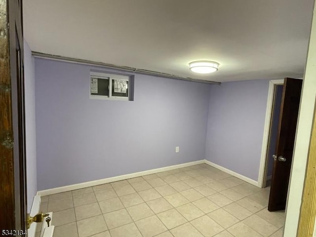 finished basement featuring baseboards and light tile patterned flooring