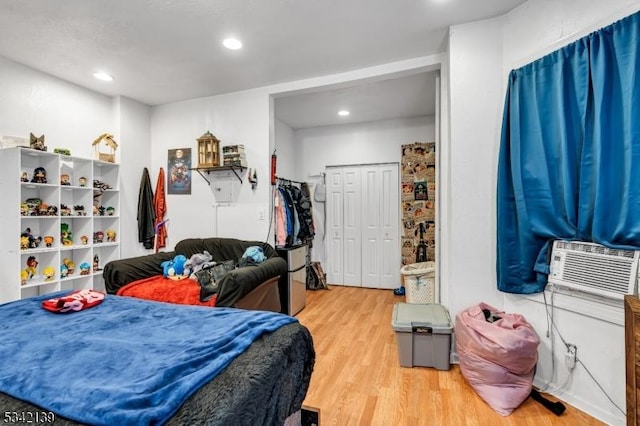 bedroom featuring cooling unit, wood finished floors, and recessed lighting