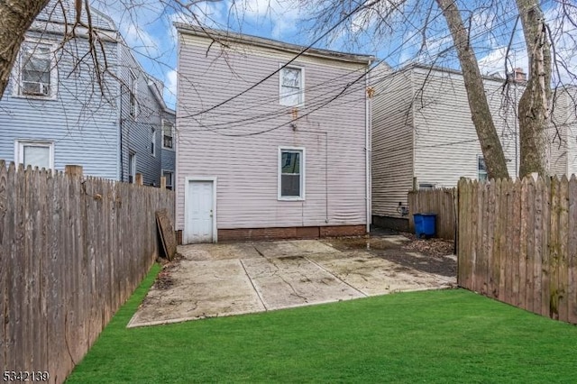 rear view of house featuring a patio area, a lawn, and a fenced backyard