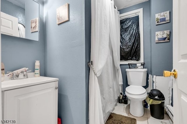 bathroom featuring tile patterned flooring, vanity, toilet, and a baseboard heating unit