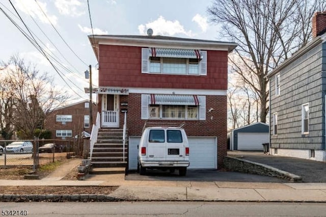 view of front of property featuring a garage, driveway, fence, and brick siding