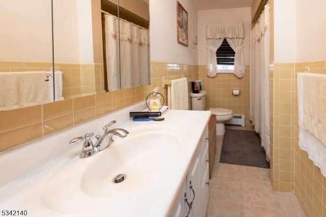 full bathroom with a wainscoted wall, tile walls, toilet, baseboard heating, and vanity