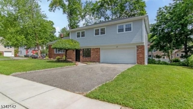 view of front facade featuring driveway, brick siding, a garage, and a front yard