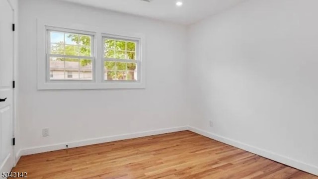 empty room featuring light wood-style floors, recessed lighting, and baseboards