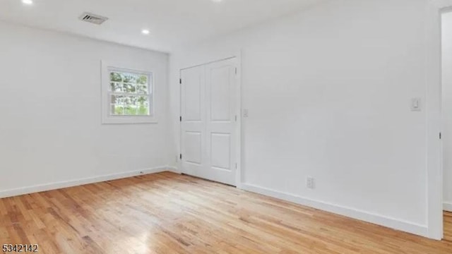 spare room with light wood-style flooring, visible vents, and baseboards