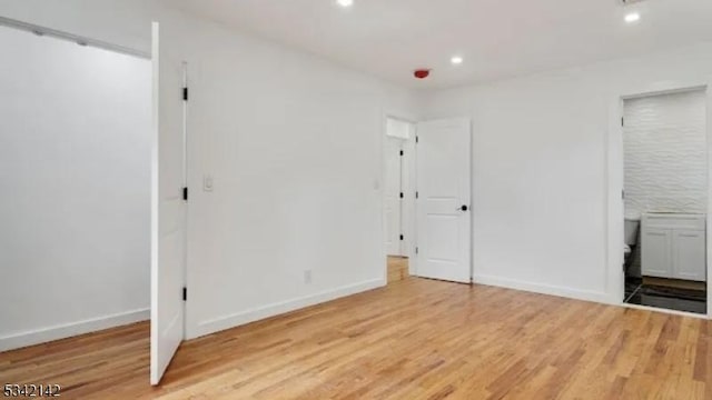 unfurnished bedroom featuring light wood-style flooring, baseboards, and recessed lighting