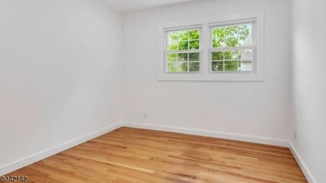 empty room with light wood finished floors and baseboards