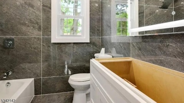 bathroom with a bath, walk in shower, toilet, and tile walls