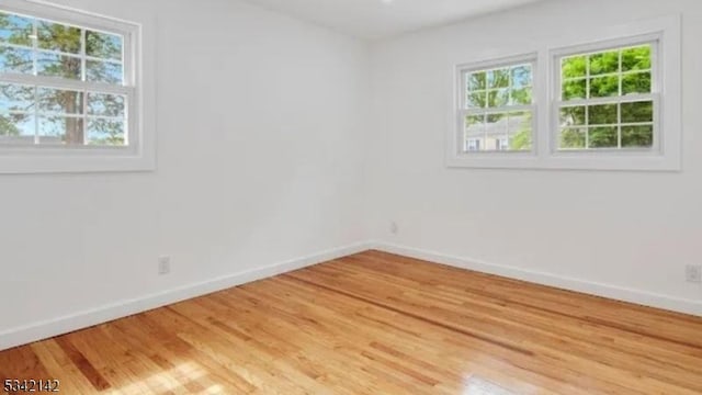 empty room featuring light wood-style flooring and baseboards