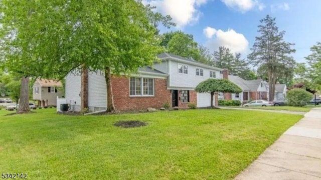 view of front of home with a garage, driveway, central AC unit, and a front yard