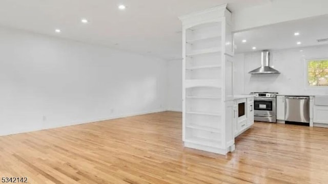 kitchen with stainless steel appliances, light wood-type flooring, wall chimney range hood, and open shelves