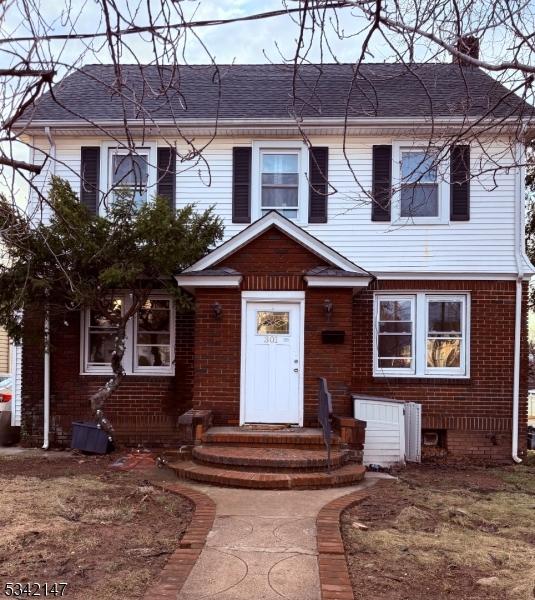 view of front of property with brick siding and a chimney